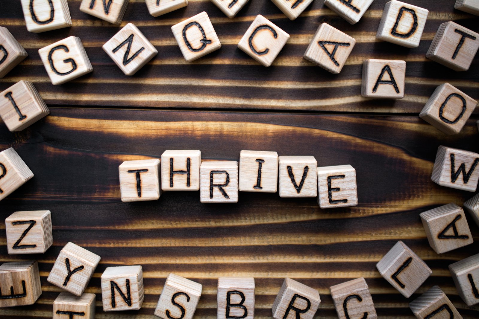 word thrive composed of wooden cubes